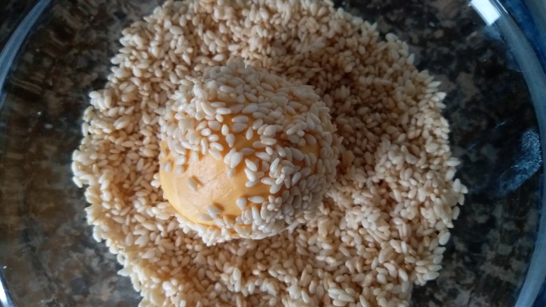 香糯南瓜饼,包好豆沙的南瓜球放进芝麻碗内,沾上芝麻