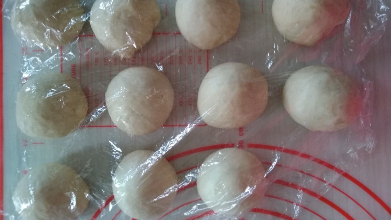 椰蓉花朵面包,发酵好的面团也分成11份,轻压排气,揉圆,盖上保鲜膜醒发15分钟