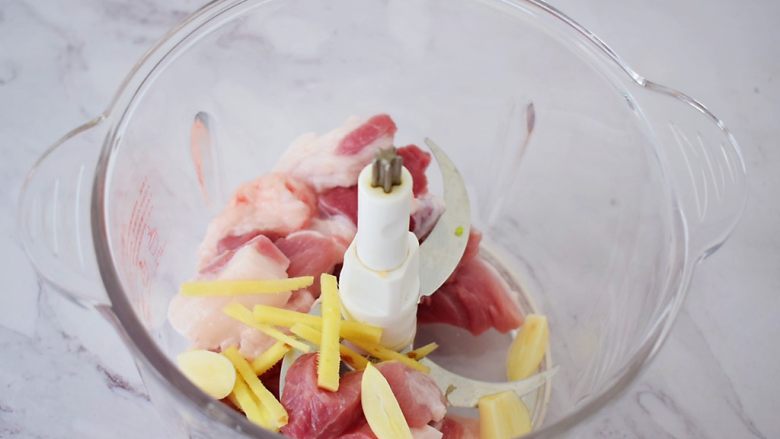 油面筋塞肉,把猪肉放入料理机中,加入姜丝、蒜片,打成肉末