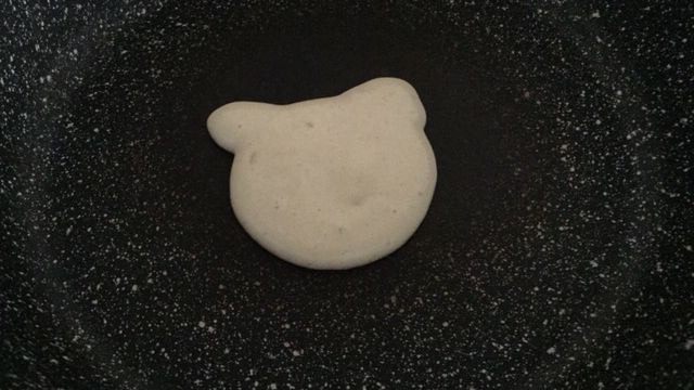 萌萌哒小熊松饼,平底锅烧热转小火,裱花袋剪小口,先在锅内挤出小熊的头,然后两边各挤出一只耳朵;