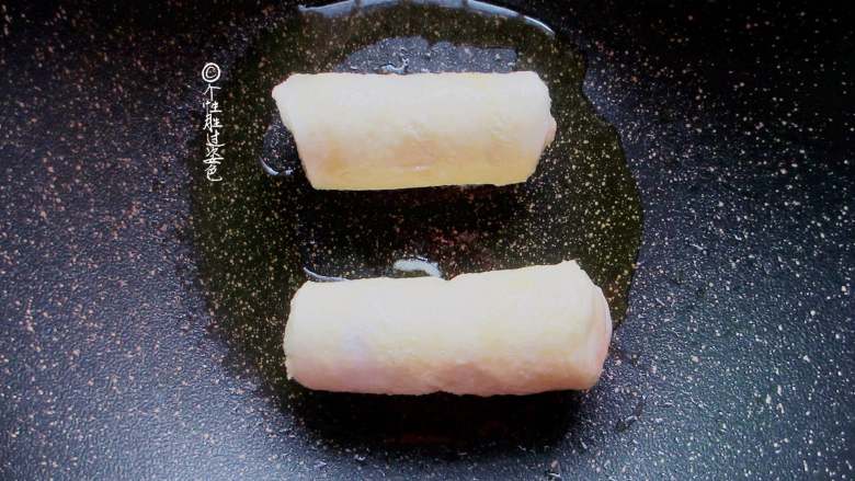 香蕉土司卷,不粘锅烧热转小火,刷薄薄一层油, 放入香蕉卷