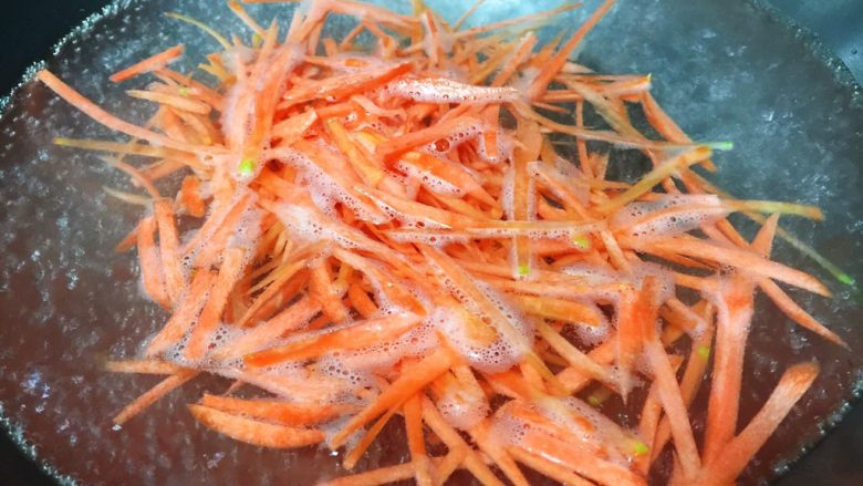 家常炝菜,锅内烧开水,放入胡萝卜丝焯熟捞出沥干水分备用