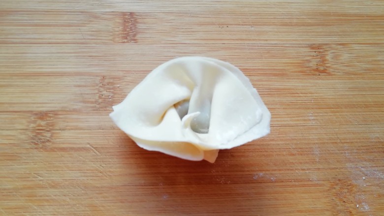 大馅馄饨,然后把两头折回来捏紧(怕粘的不紧可以沾点水),一个馄饨就包好了。