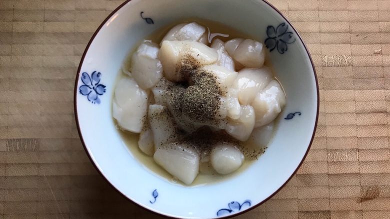 塔吉锅海鲜汇,仙贝丁洗净之后入适量料酒,少许胡椒粉,抓均匀,腌制,备用