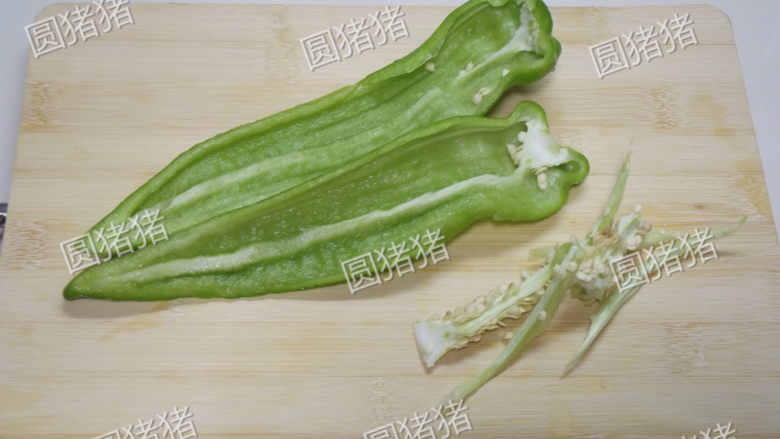 青椒炒鸡蛋,将青椒对剖开,取出椒籽。
