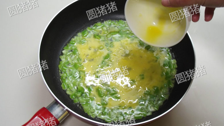 青椒炒鸡蛋,倒入鸡蛋液,并把青椒碎在中间摊匀。