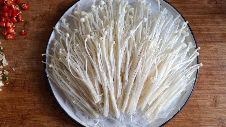 蒜蓉粉丝蒸金针菇——快手下饭就靠它,将洗净的金针菇切根,撕开铺在粉丝上。