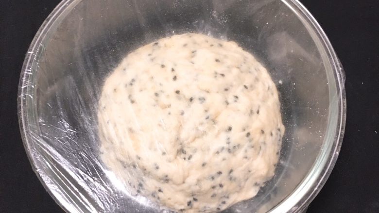 松软芝麻包,面团放入玻璃碗中,盖上保鲜膜静置40分钟,后放入冰箱冷藏过夜。