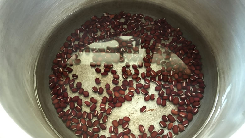 紫米红豆南瓜圆子粥,红豆先放入锅中,加入足量的水大火煮开。