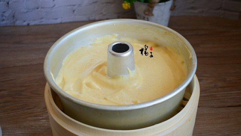 南瓜蒸蛋糕,锅中烧开水,将模具放锅中蒸40分钟,记得一定要在模具上盖一个盘子,以免锅盖上的水蒸汽滴落在蛋糕上,出锅倒扣晾凉后脱模