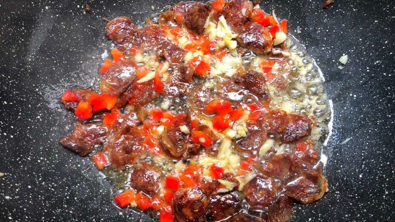 腊肠炒甜豆,放入红椒丁和蒜末,大火炒出香味。