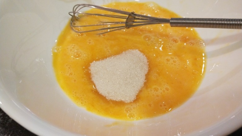 新文美食 日式煎松饼,碗中打入两个<a style='color:red;display:inline-block;' href='/shicai/ 9'>鸡蛋</a>,加入适量白沙塘用打蛋器搅拌均匀。