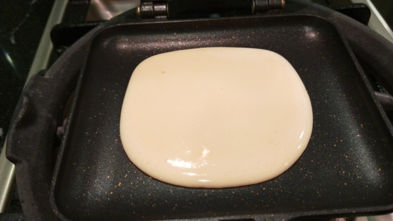 新文美食 日式煎松饼,不沾锅烧热,不加油,直接倒入一勺面糊摊成小圆饼。