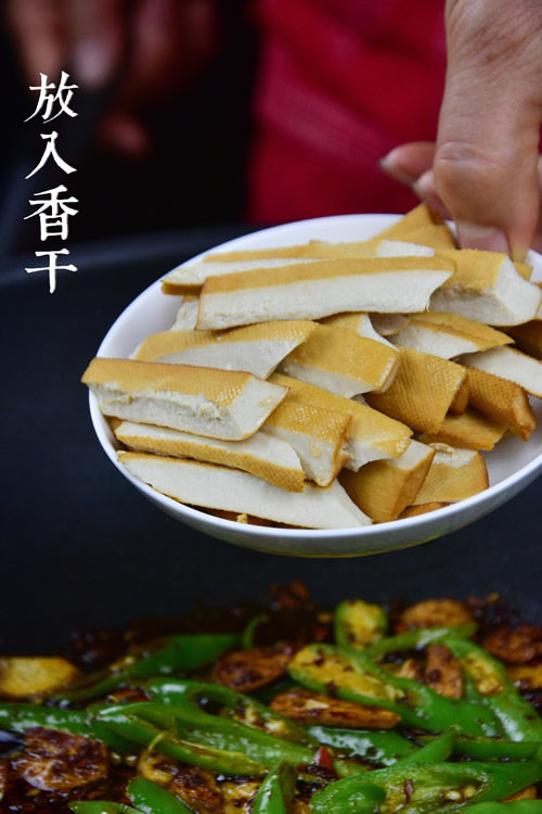 腊肉炒香干,放入切好的青椒、豆干,炒至断生。