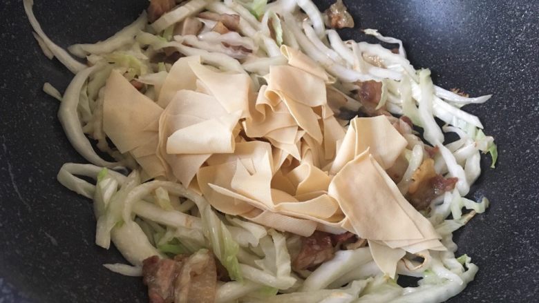 白菜肉片煲,放入百叶翻炒均匀。