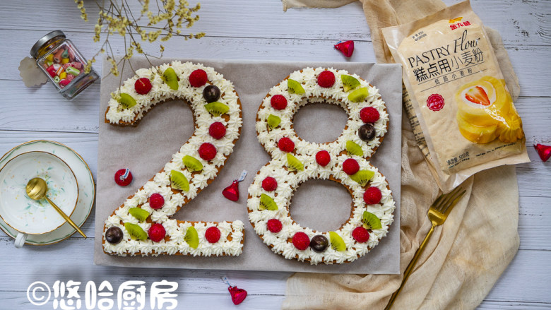 数字生日蛋糕,盖上另一片蛋糕,继续在蛋糕边缘挤上一圈淡奶油,在空隙中摆上树莓、猕猴桃块和水滴巧克力。蛋糕放入冰箱冷藏定型,吃之前取出即可。