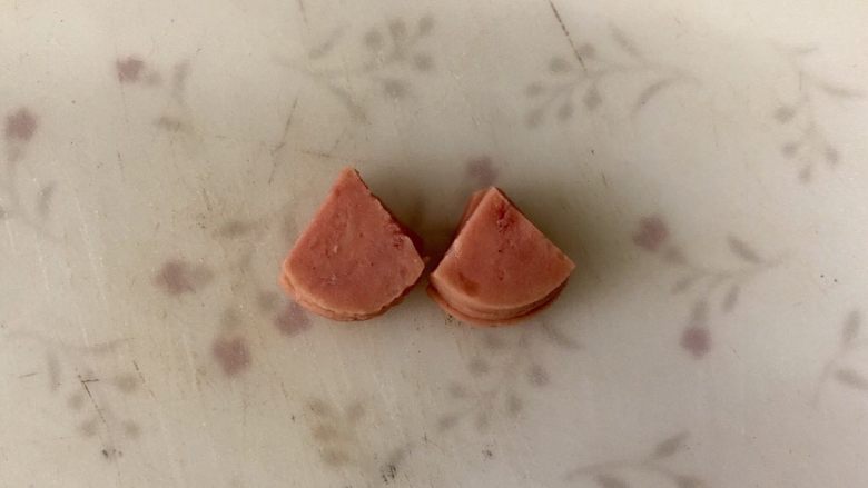 黄金小猪馒头片,正圆的火腿片,切成如图的小扇形,做小猪的耳朵。