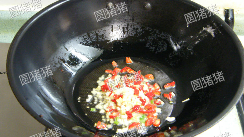 金针酸汤肥牛,接下来放入姜,蒜,泡椒段及酸笋丁炒出香味。