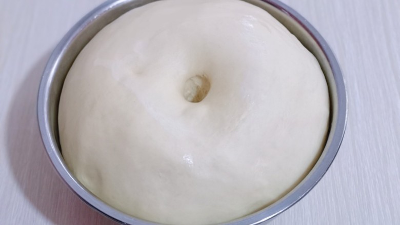 日式炼乳蔓越莓面包,发酵好的面团是原来的两倍大,用手指按一下,不回缩即为发酵完成!取出揉圆排气,盖上保鲜膜醒10分钟!