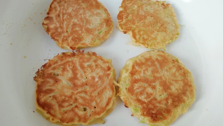 萝卜虾皮鸡蛋饼,鸡蛋饼一面定型以后翻面继续煎,煎至两面金黄即可关火出锅。
