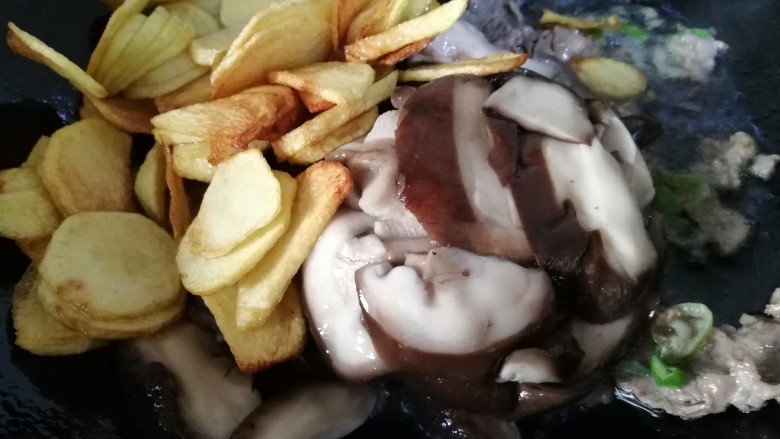 蚝油肉炒香菇土豆片,接着放入炸好的土豆片,焯熟切好的香菇片。