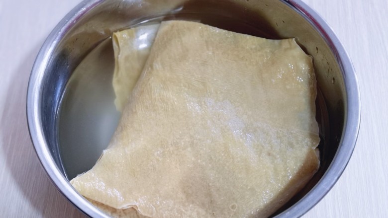 清爽可口~凉拌豆腐皮,首先将豆皮用温水泡软!