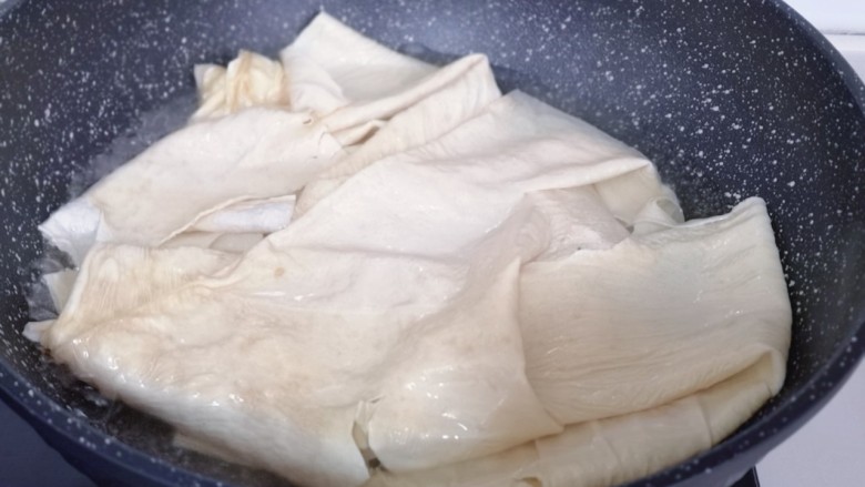 清爽可口~凉拌豆腐皮,豆腐皮泡软后再焯水:锅中加入水烧开,放入泡好的豆腐皮,煮1分钟即可捞出!