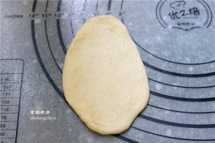 脆皮肠小面包,取一个小面团,用擀面杖擀成牛舌状;