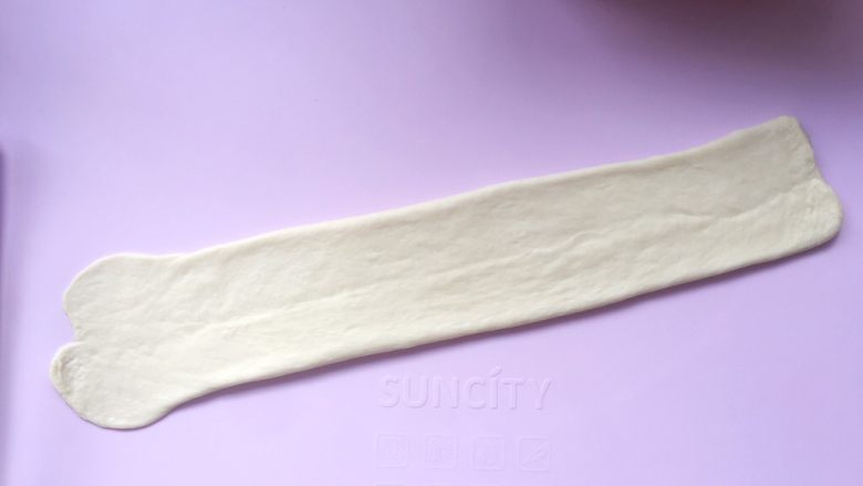 烫种吐司,用擀面杖轻轻擀一下,将面片擀宽一点,尾部稍微擀薄一点;