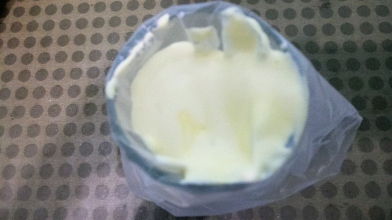 蛋黄溶豆,然后把杯子放一个裱花袋,再把面糊倒入到裱花袋中。