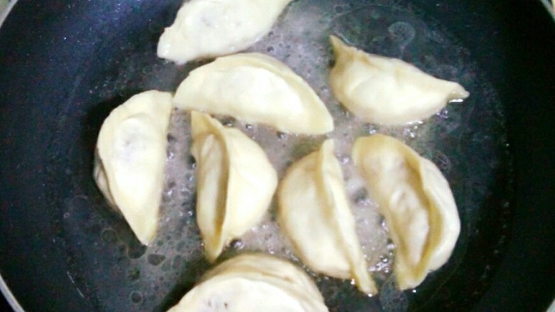 牛肉大萝卜煎饺,加入清水,没过饺子三分之一,盖上盖中火蒸