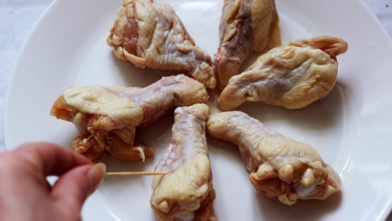 秘制叉烧酱烤鸡根,把洗净沥干水分的鸡根,用牙签在鸡肉上扎孔,尽量的多扎几下以便入味。