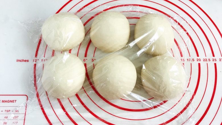 贝果汉堡包,将发酵好的面团取出排气,平均分成6份,接着滚圆,盖好保鲜膜松弛15分钟。