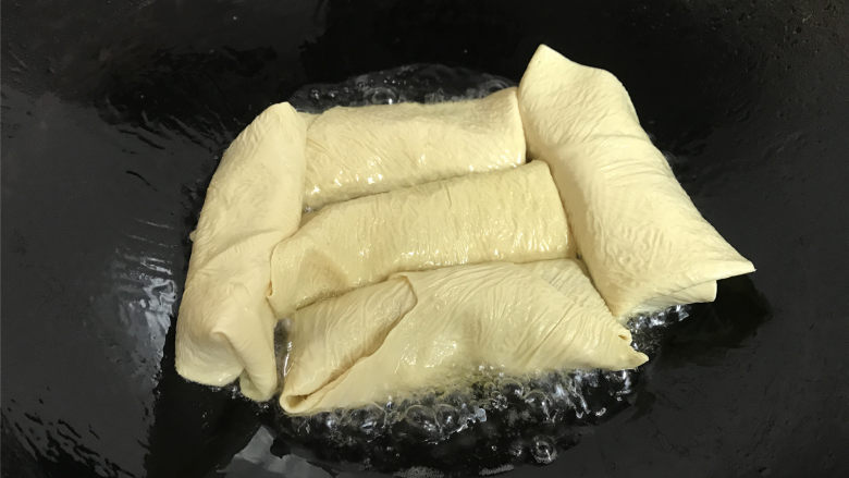 豆腐皮包肉,锅中倒入适量油,放入包了馅的豆腐皮卷。