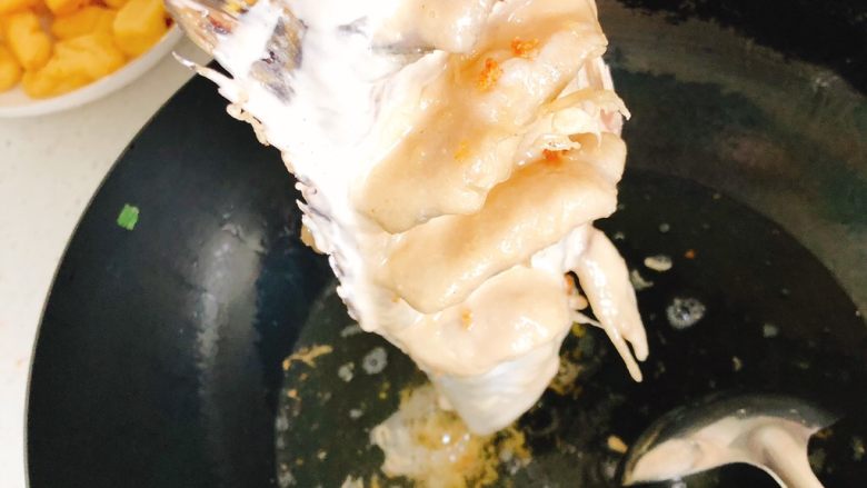 年年有余之糖醋鱼-年夜饭,锅里倒入食用油,烧至7层热时,手拎着鱼尾,将油从上到下浇到鱼身上,使刚才切的鱼片展开定型。