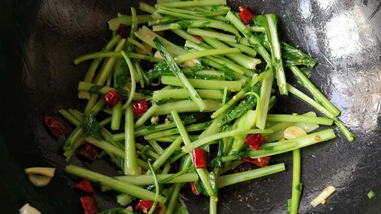 苔菜炒肉丝,将苔菜茎大火翻炒至7、8成熟。