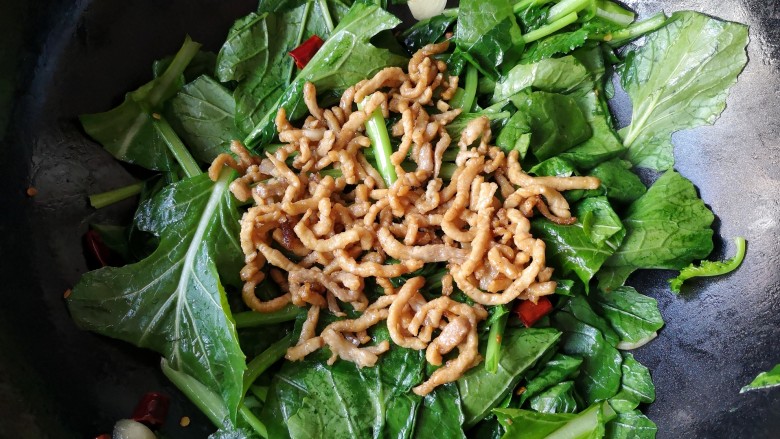 苔菜炒肉丝,待苔菜叶炒塌后放入炒好的肉丝,继续大火快炒。