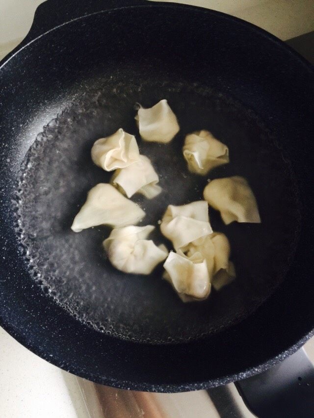 馄饨,锅中加适量的水烧开后下馄饨。我煮的是1人份，10个馄饨，馄饨包的比较大。看一下馄饨和水的比例。