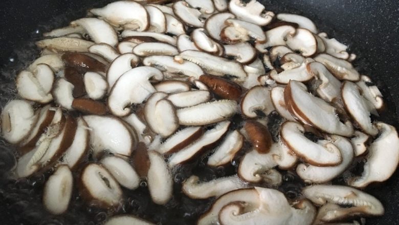 香菇炒鸡蛋,锅中加水和1克盐烧开,把香菇片焯水。