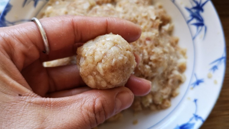 团团圆圆——珍珠圆子,手里蘸点水,将抓拌好的肉糜用手挤成肉圆。