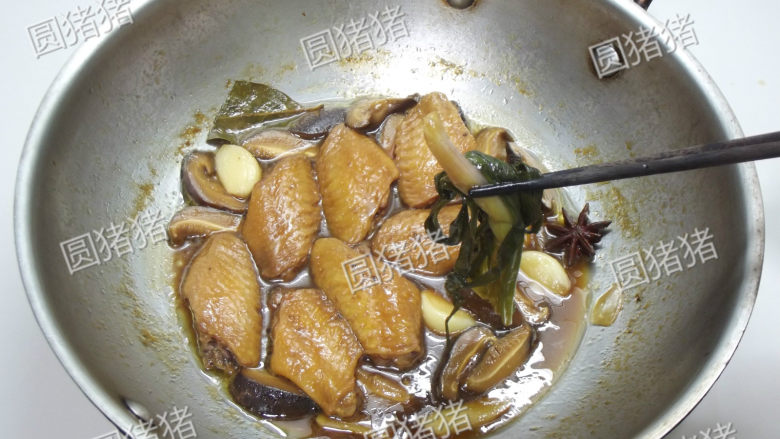 红烧鸡翅,大火烧开后,加盖小火焖约15分钟,夹出里面的葱姜蒜等香料。