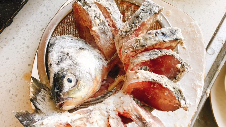 油炸糖醋版孔雀开屏鱼-年夜饭、宴请菜类,取一个干燥的漏勺,把鱼展开装在漏勺里,以防鱼下锅炸时鱼肉粘连在一起,也能更好定型。