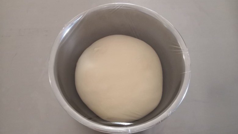椰蓉吐司,取出面团整理后,放入容器里盖上保鲜膜发酵(基础发酵在26—28度温度环境下发酵)