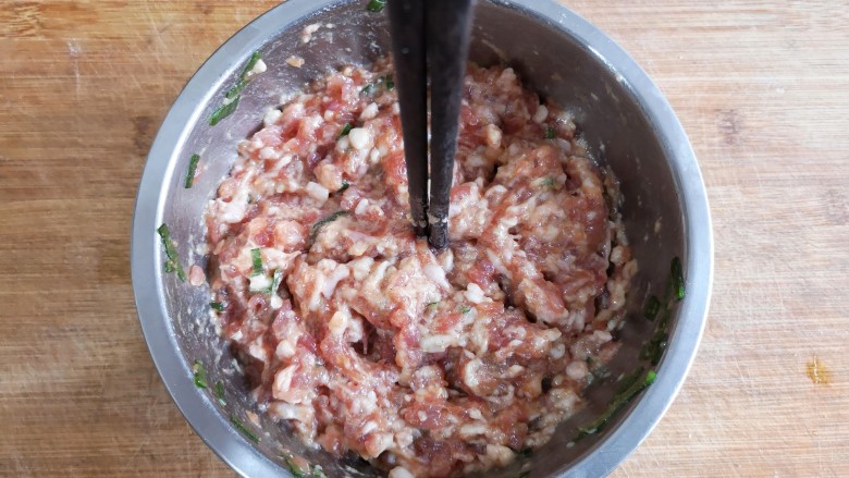 玫瑰花蒸饺,用筷子顺着一个方向搅拌肉糜使其上劲,筷子能立在肉糜中。