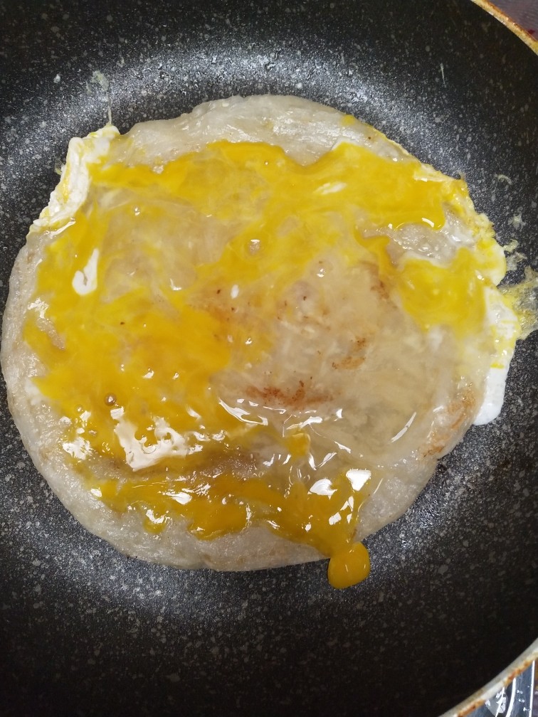手抓饼,放入饼皮，打上鸡蛋