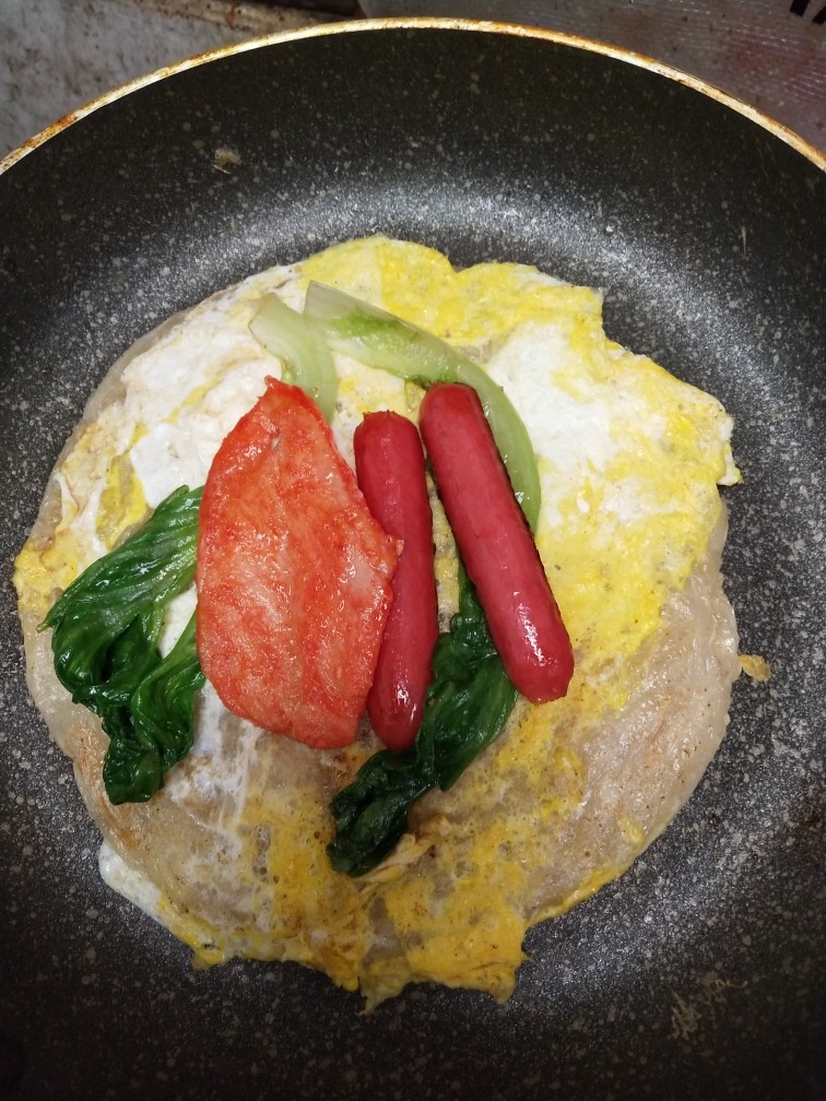 手抓饼,鸡蛋凝固后，放入配菜，稍稍热下。