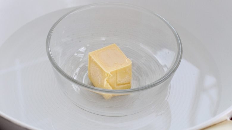万圣节蜘蛛杯子蛋糕,将黄油放进容器中隔水融化成液态,或者用微波炉加热融化,放置一旁冷却备用