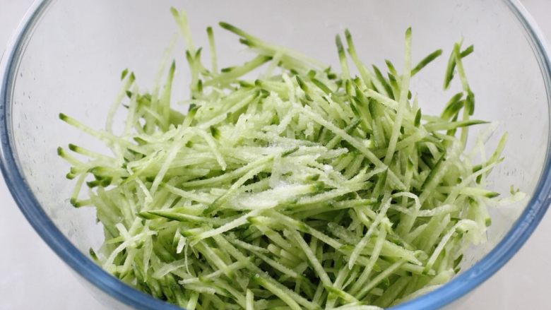 猪肉萝卜丝玉米面蒸饺,先将萝卜洗净用擦丝器擦成细丝,加入一茶匙盐拌匀,腌制15分钟左右