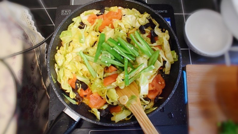 番茄炒包菜盖浇饭,炒至包菜断生(八分熟)时,加入青椒,再加入适量的<a style='color:red;display:inline-block;' href='/shicai/ 788'>生抽</a>,继续翻炒。