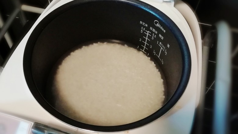 番茄炒包菜盖浇饭,将米淘洗干净后,开始在电饭锅上蒸。